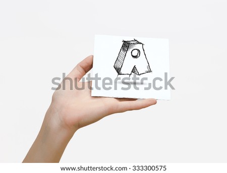 Hand holding a piece of paper with sketchy capital letter A, isolated on white.