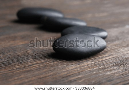 Pebbles in a row on wooden background