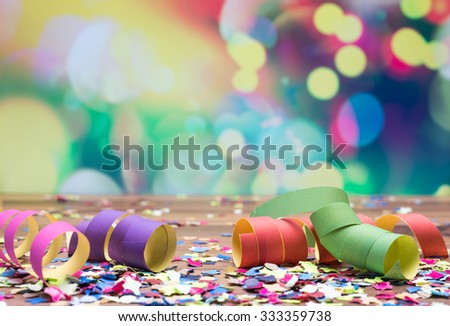 colorful confetti and streamer lying on floor in fron of background Royalty-Free Stock Photo #333359738