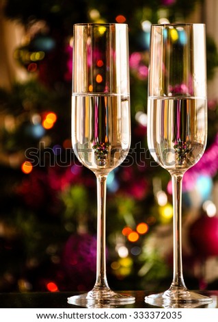two champagner glasses on glass table with bokeh background 