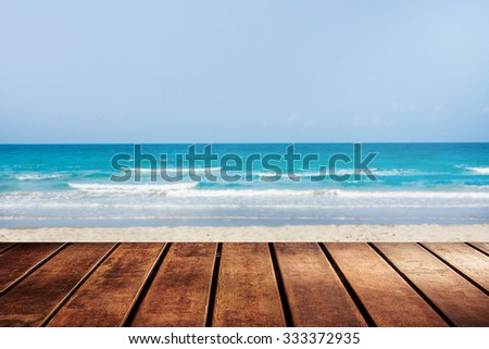 wooden platform beside blue sky beach with palm tree.