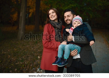 Smiling couple playing with their beloved baby girl in the park