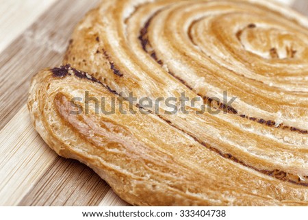 Closeup shot of danish pastry swirl with milled hops. Studio shot on wooden table.