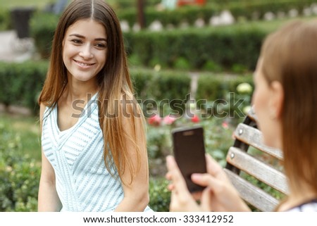 No better photographer. Selective focus on a beautiful young female posing for a photograph her friend is taking with the phone
