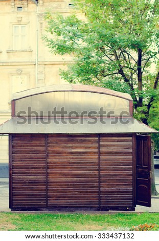 Wooden stall on a green lawn. Street view