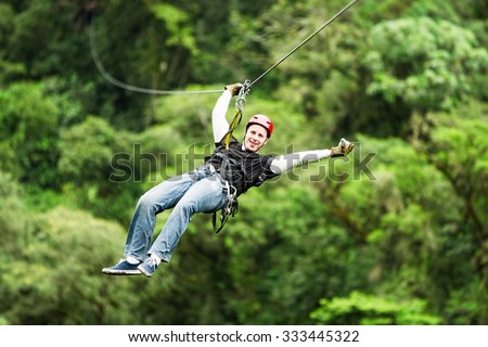 An exhilarating zipline adventure through the lush Ecuadorian rainforest canopy, soaring above the trees on a secure wire for an unforgettable experience. Royalty-Free Stock Photo #333445322