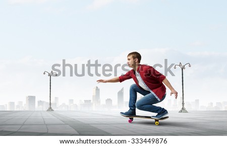 Handsome teenager cool acive boy riding skateboard