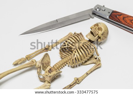human skeleton with swiss knife on white background