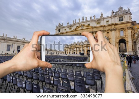 Taking pictures on mobile smart phone in Multiple rows of black seats. Vatican