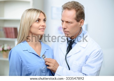 Involved in work. Agreeable professional doctor holding stethoscope and examining his patient 
