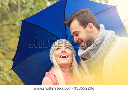 A picture of a couple holding umbrella in the park
