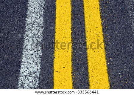  Asphalt road texture with yellow and white stripes.