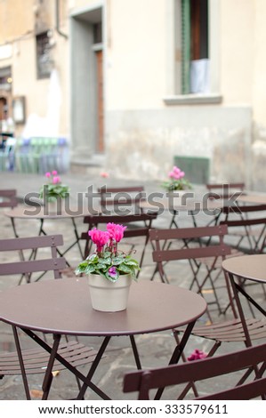 A table in italian street cafe,  european houses and streetview in the background