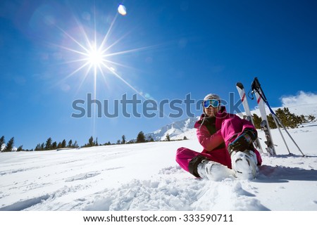 Ski, snow and sun - resting female skier in winter resort Royalty-Free Stock Photo #333590711