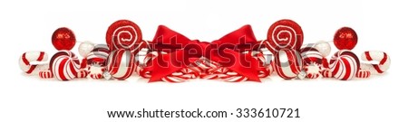 Christmas border of red and white baubles, bows and candy canes isolated on a white background