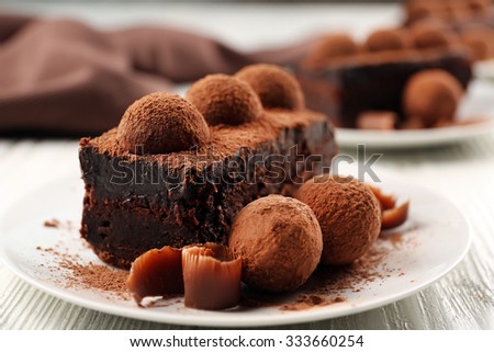 Slices of chocolate cake with a truffle on plate closeup
