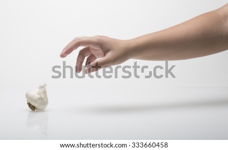 Hand Reaches for Garlic Royalty-Free Stock Photo #333660458
