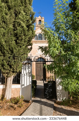Gate and pathway to  courtyard with a small family church or chapel with belltower