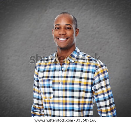 Young smiling African-american businessman over grey wall background.