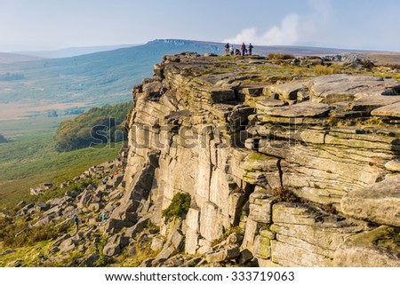 Stanage Edge in Peak District with hikers in bacground, England, UK. Royalty-Free Stock Photo #333719063