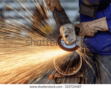 Electric wheel grinding on steel structure in factory (Low speed shutter)