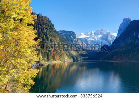 Beautiful autumn scenery of Lake Gosausee with snow-capped Dachstein Mountain in the background and reflections on the smooth water, in Gosau, Austria. A dramatic unusual scene of Alps, Europe.