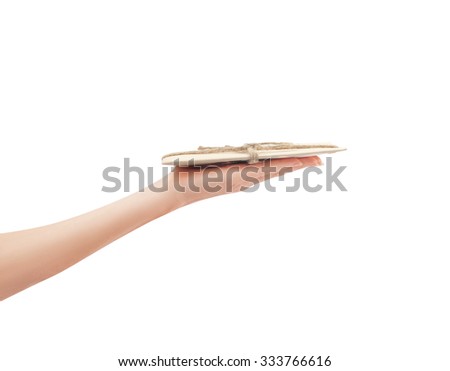 Woman's hand is bringing a vintage brown envelope tied with linen rope, side view photo isolated on a white background.