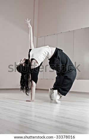 sporty girl standing in bridge. photo in dance studio