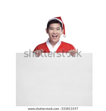 Young man in Santa Claus costume behind white board with space for text over white background