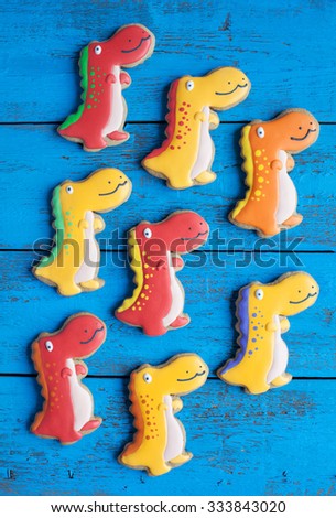 Homemade gingerbread cookie in the shape of dinosaurs on a wooden background. Space for text and selective focus.