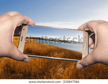 Image of shooting photographs with smart phone on view, Photographer holding mobile smart phone with photograph and photography
