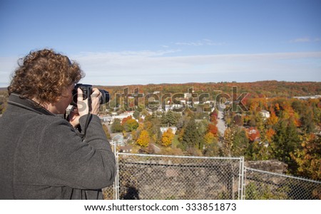 Woman photographer shooting autumn landscape
