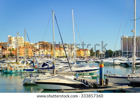 Picture of many beautiful yachts mooring in harbour. Sunny day in port with luxury boats on summer blue sky outdoor background.