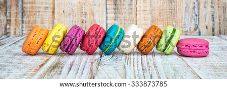 Colorful macarons on vintage pastel background. Macaron or Macaroon is sweet meringue-based confection. 