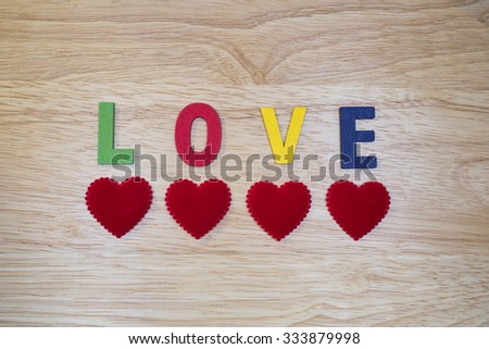 Colorful words "Love" made from wooden letters on wood background (Valentines day)