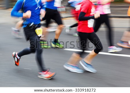 picture with creative motion blur effect made by camera of running people at a city marathon