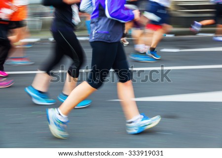 picture with creative motion blur effect made by camera of running people at a city marathon