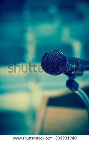 Closeup Microphone on the speech podium over the Abstract blurred photo of conference hall or seminar room background