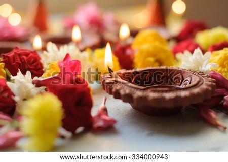 diya lamps lit during diwali celebration with flowers and sweets in background Royalty-Free Stock Photo #334000943