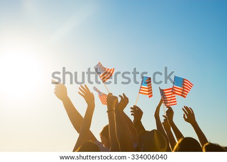 Fans on the concert of your favorite pop stars. Young people waving American flags. Fans at the match with his arms raised. Pride in their country.