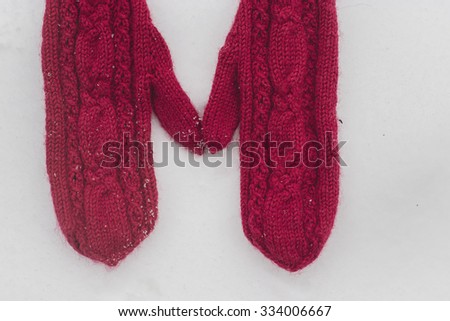 red mittens on snow horizontal view