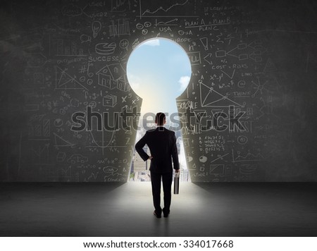 Business man looking at keyhole with bright cityscape concept background