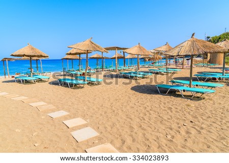 Umbrellas and sunbeds on sandy Potami beach, Samos island, Greece