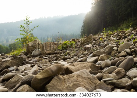 Beautiful rocky mountain landscape. Stones and boulders strewn shore of a mountain river. Photo for Natural magazines, posters, backdrops and websites.