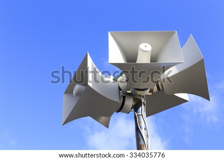 loudspeaker warning system. system of alert for population: sound amplifier with loudspeaker against the sky Royalty-Free Stock Photo #334035776