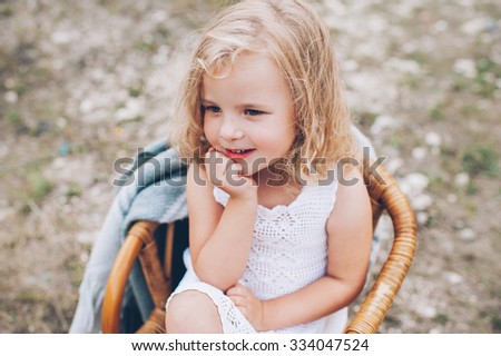 happy little girl in a chair outdoors