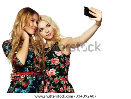 life style, happiness, emotional and people concept: two young women taking selfie with mobile phone 