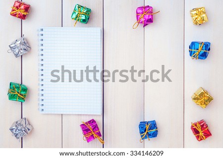Boxes with gifts on a light wooden boards. White notepad. Happy new year. Space for text. Old background. New Year background.