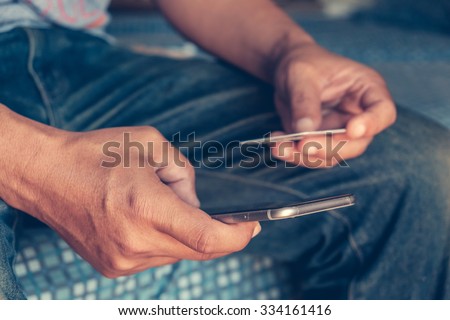 Man holding smart phone and credit card. Shopping Online. Vintage or pastel effected photo. Royalty-Free Stock Photo #334161416
