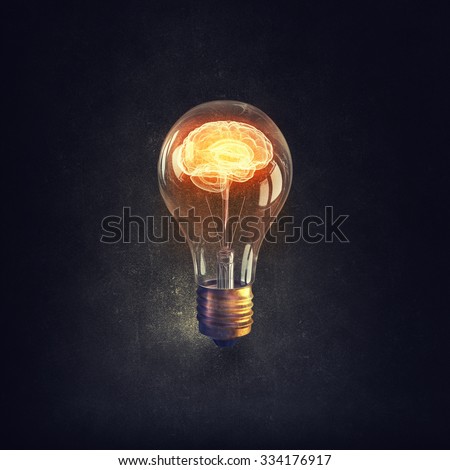Human brain glowing inside of light bulb on dark background Royalty-Free Stock Photo #334176917